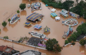 In this aerial photo, an amusement park is surrounded by flood water in Franco da Rocha, in the greater Sao Paulo area, Brazil, Friday, March 11, 2016. Brazilian officials say mudslides and flooding caused by heavy downpours killed at least 16 people including a 4-year-old boy in low income neighborhoods on the outskirts of Sao Paulo. (AP Photo/Andre Penner)